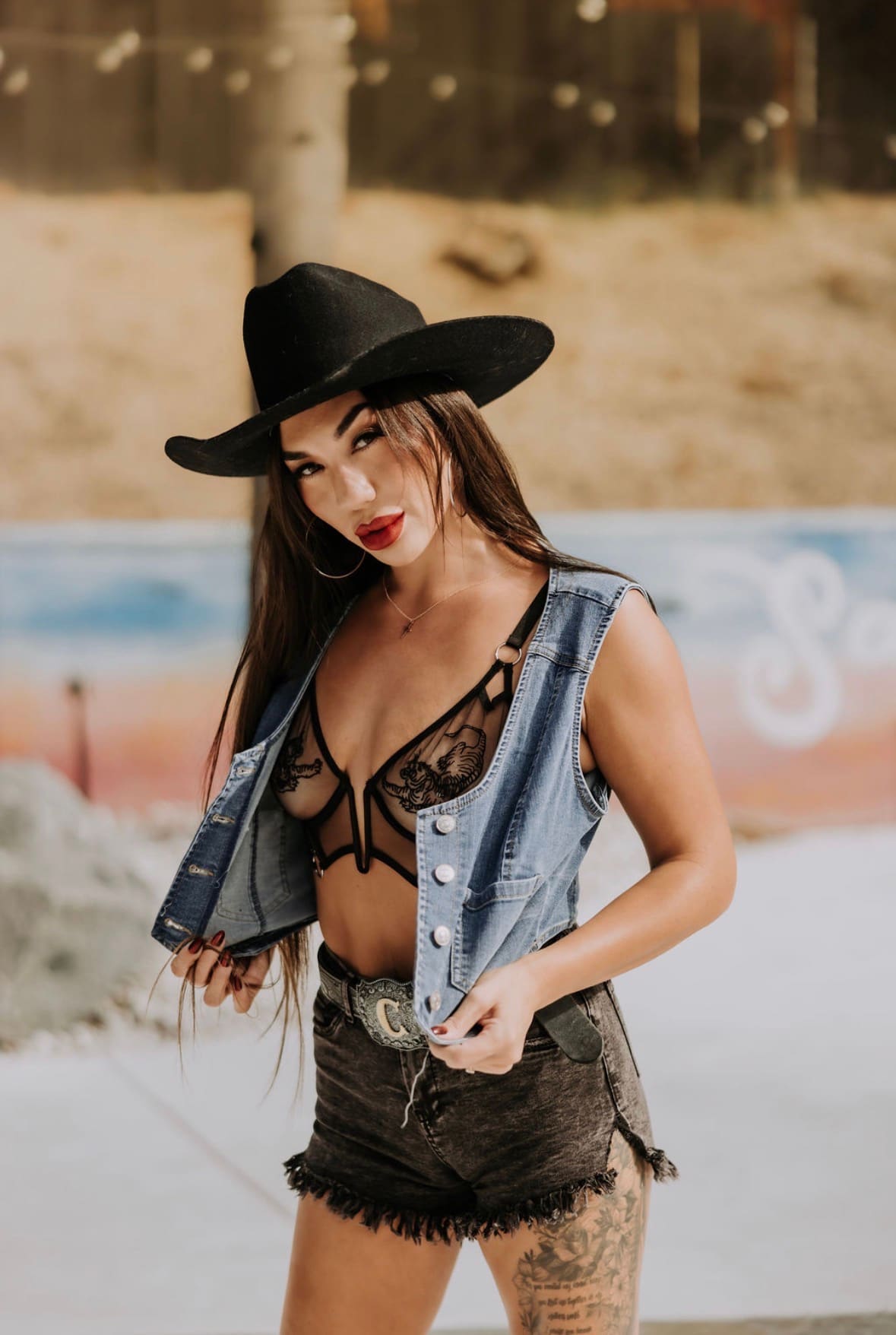 Divinity Ray in a black cowboy hat and denim vest